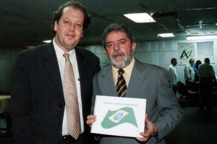 2002 | Presidente da Anhembi Turismo e Eventos de SP (atual SPTURIS), entrega a Lula, ainda candidato a presidente, a proposta para o programa de turismo